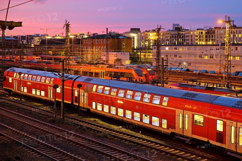 Elevated view of a double-decker commuter train at sunset