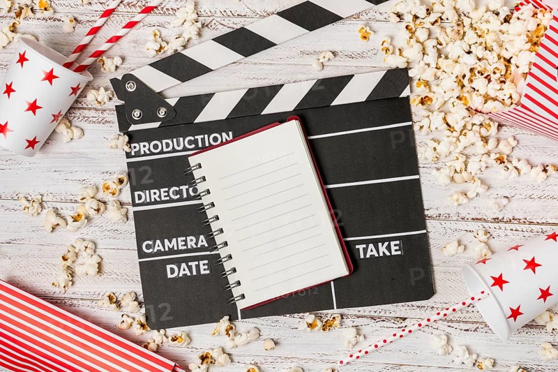 Spiral notepad clapperboard drinking straw popcorns wooden desk