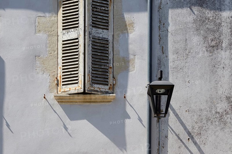 Old shutters and lantern on a facade in Le Chateau-d'Oleron