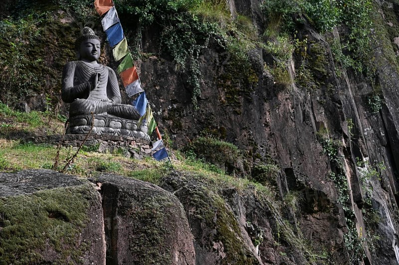 Buddha statue and Tibetan prayer flags in front of the entrance to the Messner Mountain Museum near Bolzano