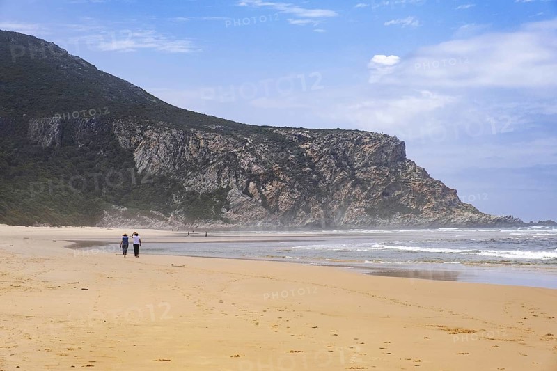 Tourists walking on Nature's Valley sandy beach in the Tsitsikamma Section of the Garden Route National Park