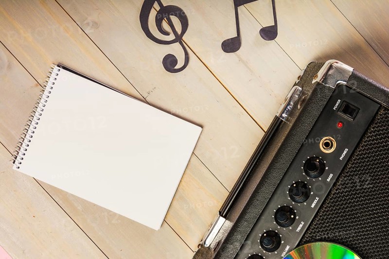 Overhead view spiral notepad musical note amplifier wooden desk
