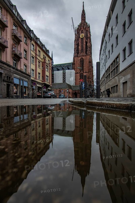 Reflection in a puddle between a historic city centre. Cityscape at the Roemer and the historic houses and streets. Cityscape in Frankfurt am Main