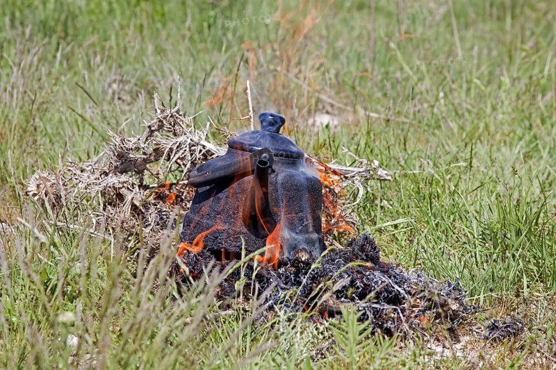 A blackened kettle boiling water in the flames of on an open campfire for making tea