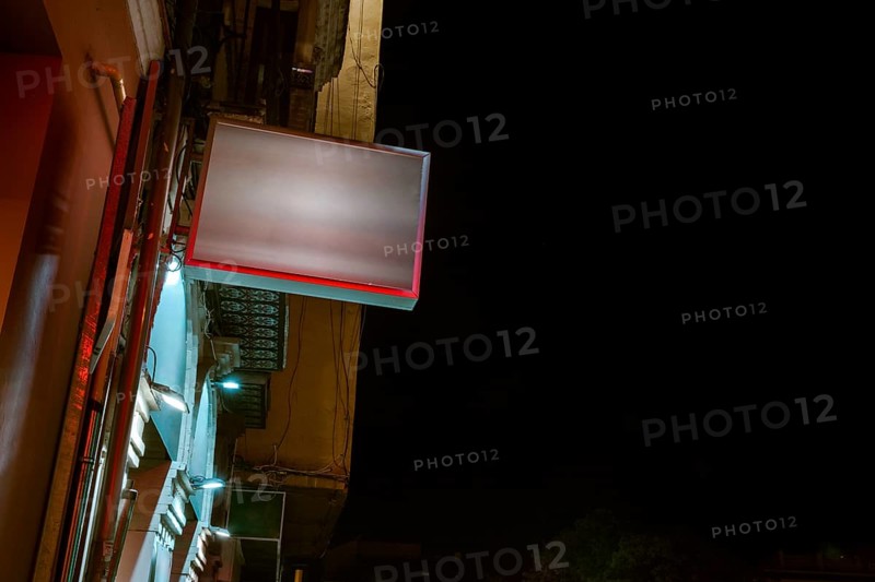 Low angle view illuminated billboard residential building against sky