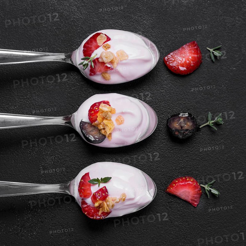 Top view collection spoons with yogurt fruits