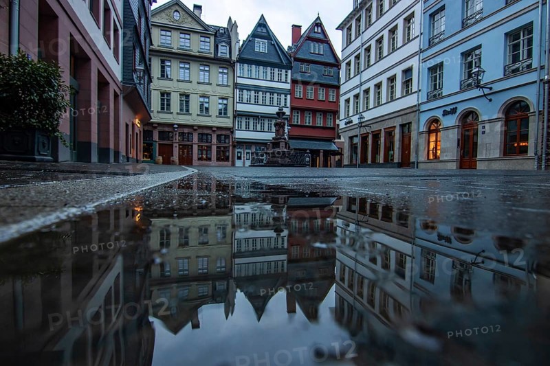 Reflection in a puddle between a historic city centre. Cityscape at the Roemer and the historic houses and streets. Cityscape in Frankfurt am Main