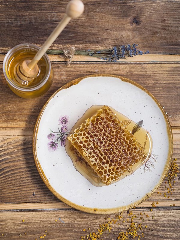 Lavender honey pot with wooden honey dipper bee pollens wooden table