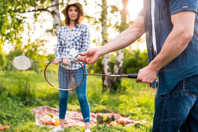 Young couple playing badminton picnic