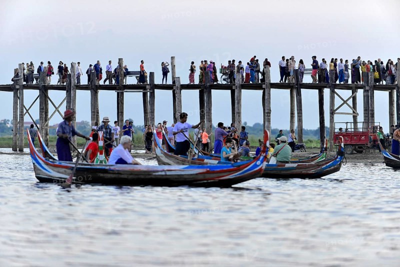 Locals and tourists on a teak bridge