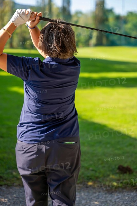 Female Golfer Making a Golf Swing in a Sunny Day in Switzerland