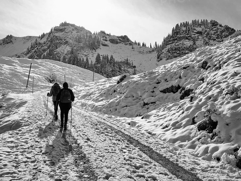 Two female hikers climbing up to the Bodenschneidhaus in winter