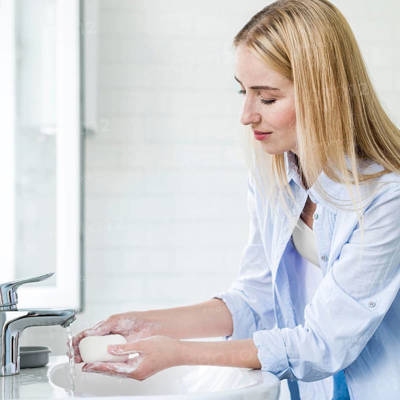 Side view woman washing her hands with bar soap