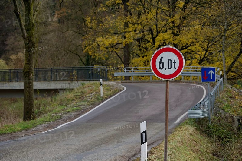 Signs with traffic regulations for weight restriction and right of way on bridge with narrow road width