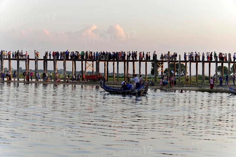 Locals and tourists on a teak bridge