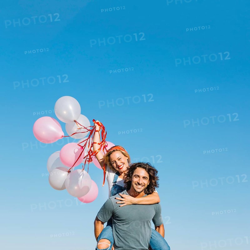 Woman with balloons back man