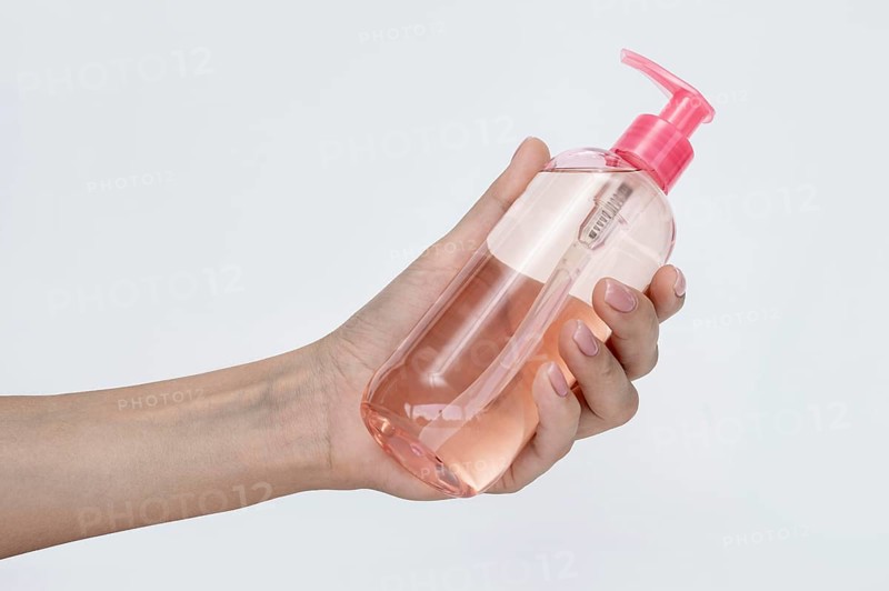 Side view person holding bottle liquid soap