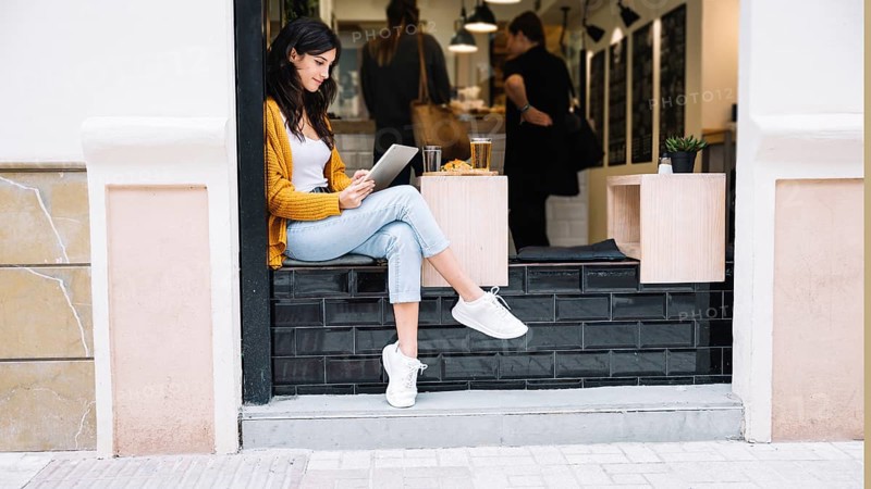 Woman sitting cafe table with tablet