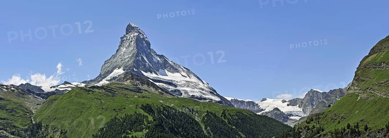 Panoramic view over the Matterhorn mountain with alpine meadows and pine forests in the Swiss Alps