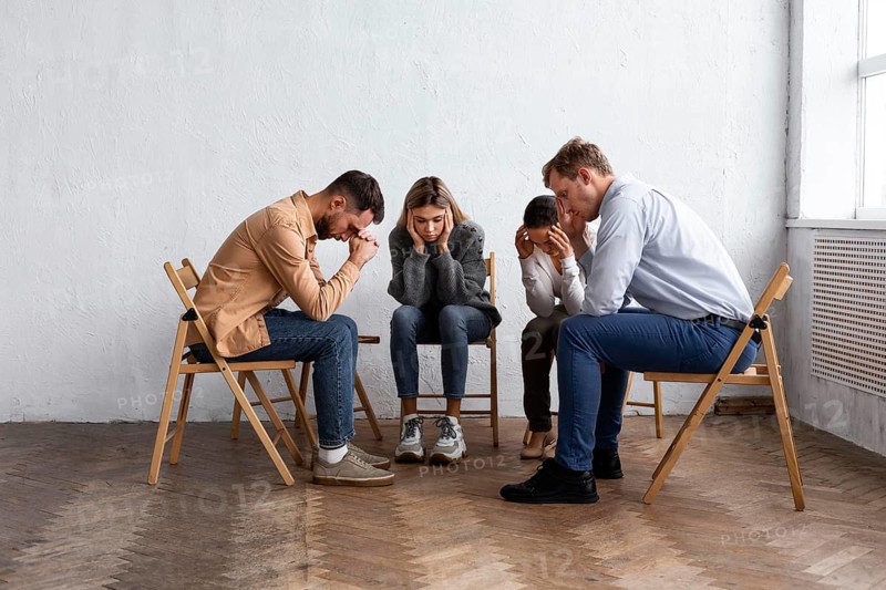 Sad people chairs group therapy session