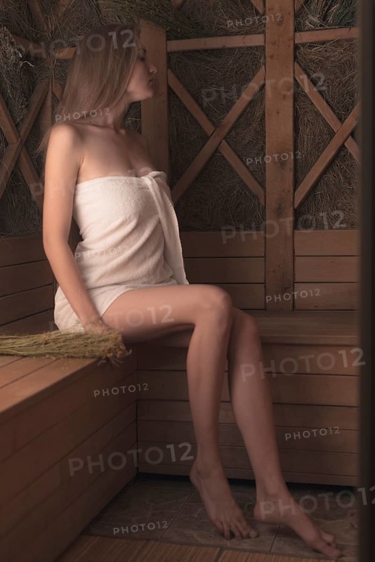 Sexy blonde young woman sitting wooden bench relaxing spa