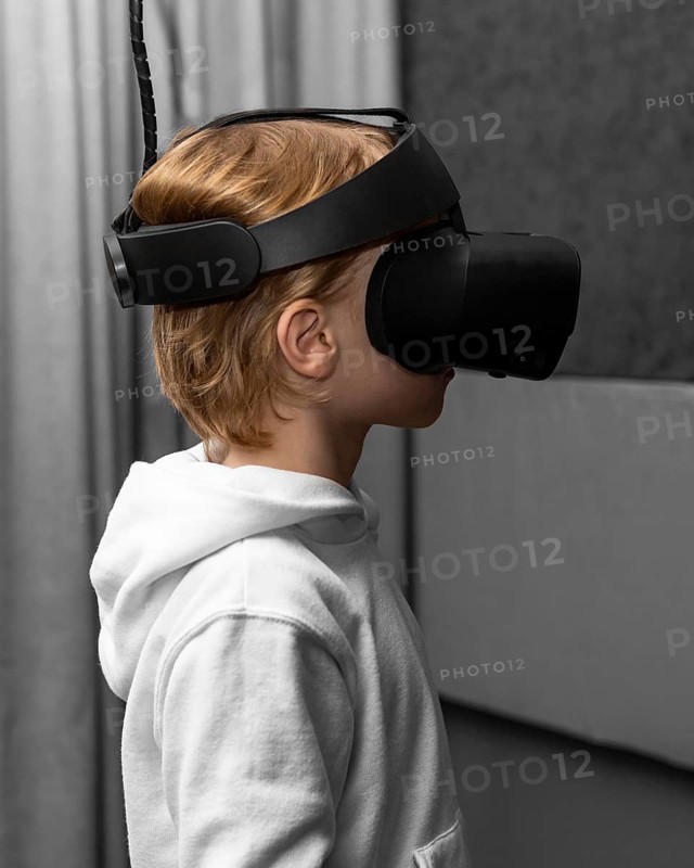 Side view young boy using virtual reality headset