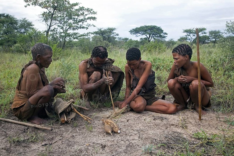 Bushman making fire by hand with wooden stick in the Kalahari desert near Ghanzi