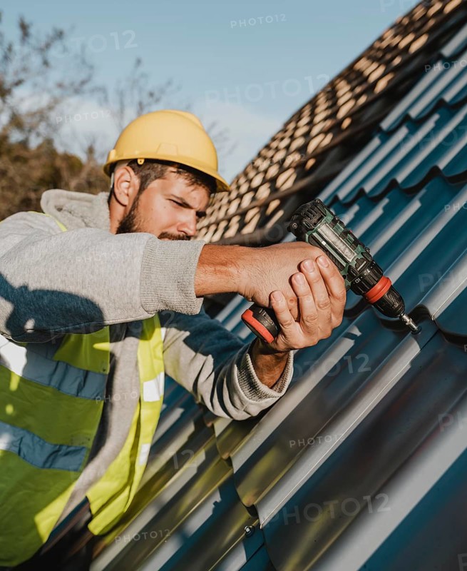 Side view man working roof with drill