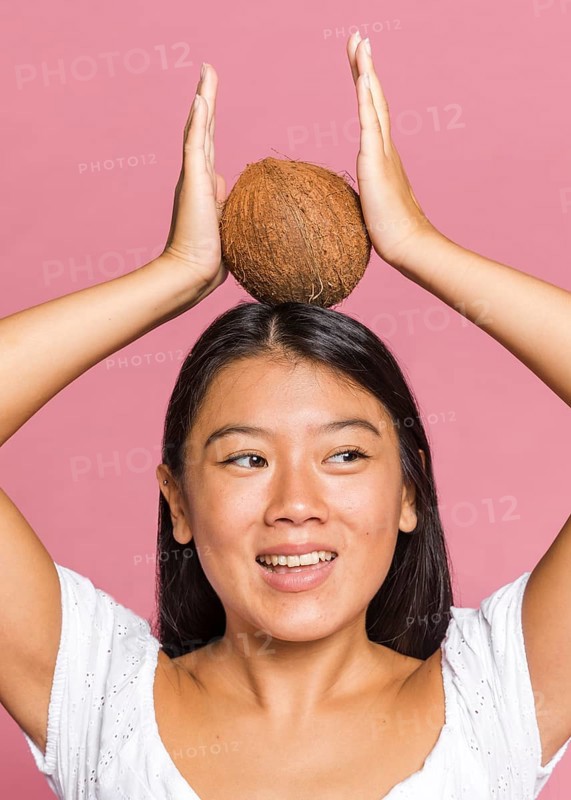 Woman holding coconut her head