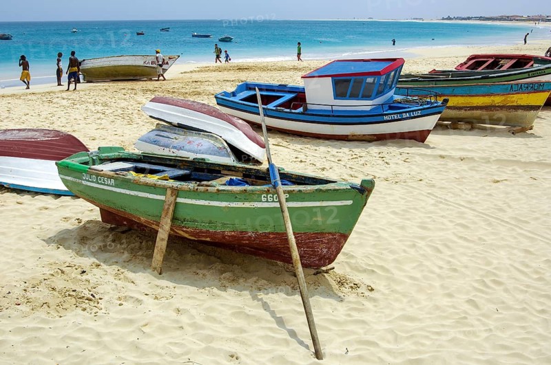 Colourful fishing boats moored on bright sandy beach