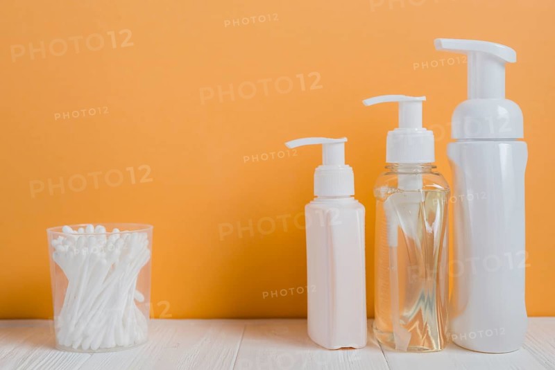 White ear buds with soap dispenser bottles white table