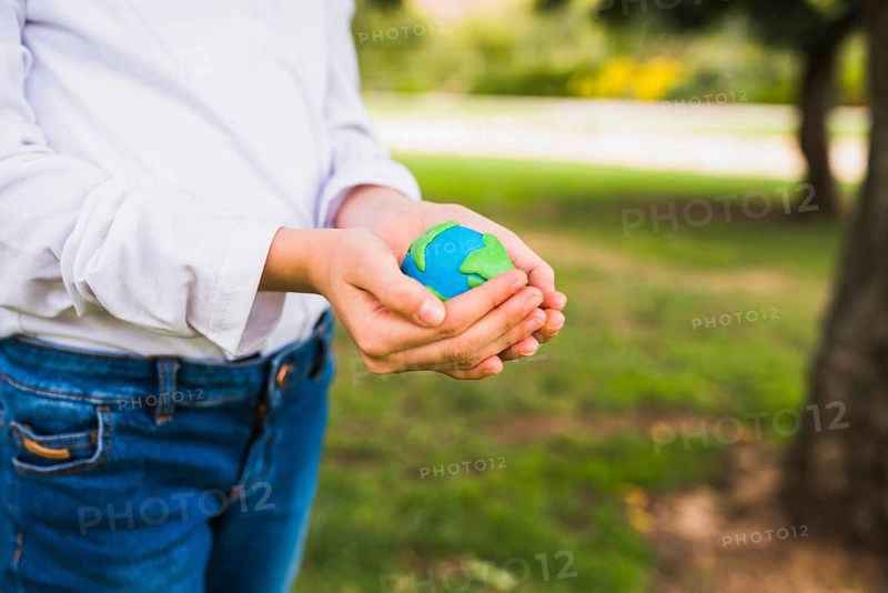 Midsection girl holding globe cupped hands