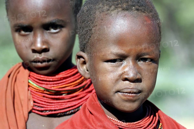Portrait of two Turkana children in traditional red clothing in northwest Kenya