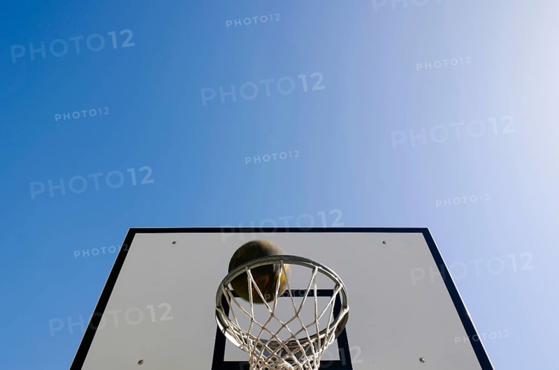 Basketball Hoop and a Ball Against Blue Clear Sky with Sunlight in Switzerland