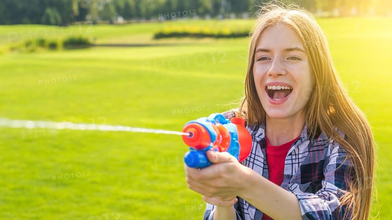 Blonde girl playing with water gun
