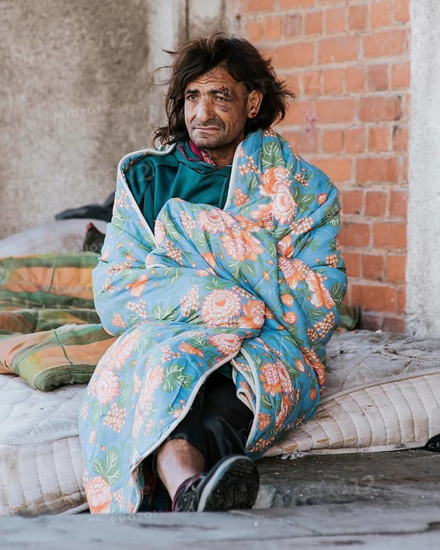 Homeless man mattress outdoors blanket