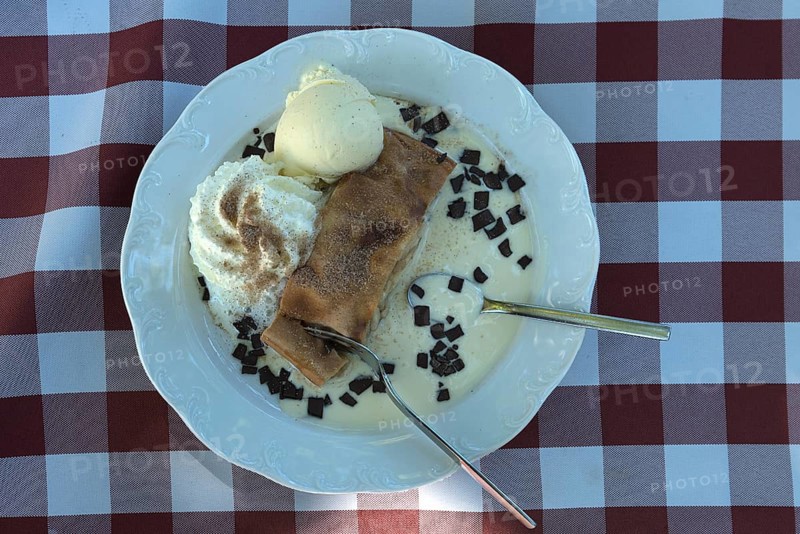 Apple strudel with ice cream and vanilla sauce served in a garden restaurant