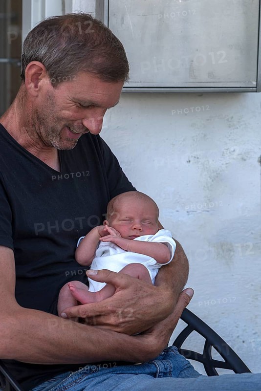 Young grandfather with his newborn grandson