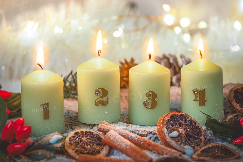 Advent candles surrounded by Christmas decorations