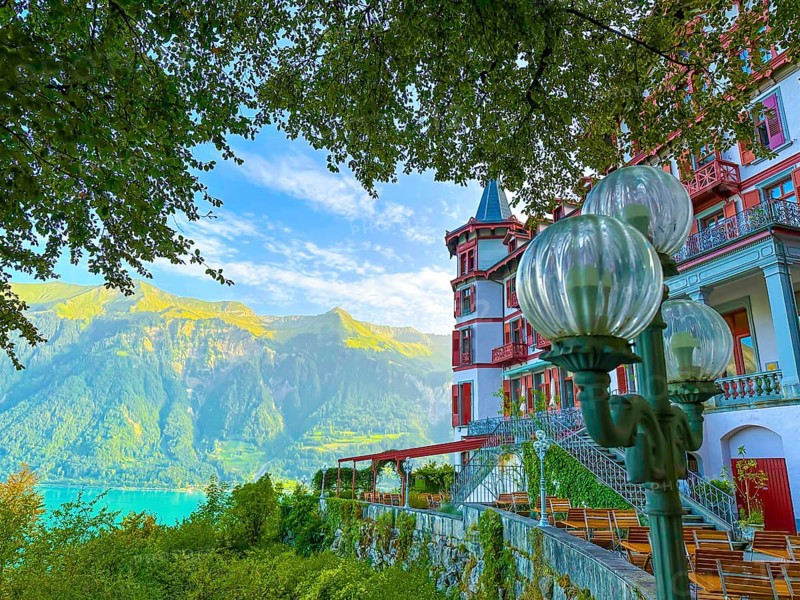 Grandhotel Giessbach with Terrace and Street Lamp and Mountain with Lake Brienz in a Sunny Summer Day in Brienz