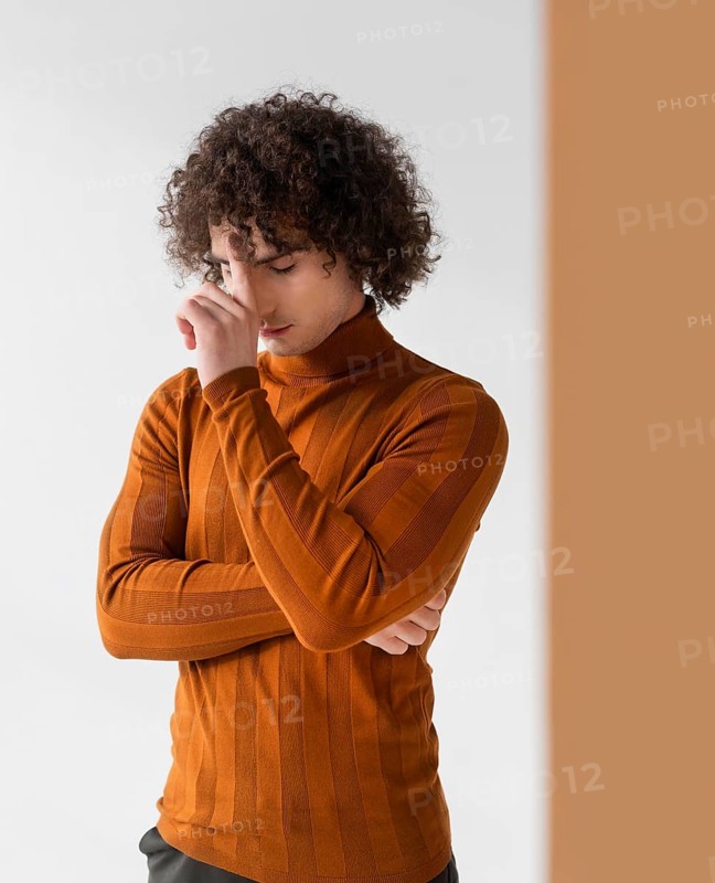 Curly man with brown blouse posing