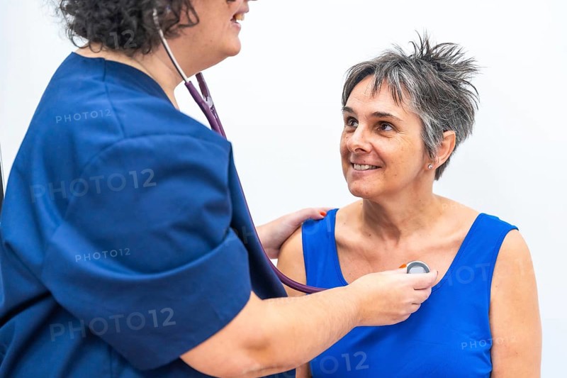 Cardiologist listening to the heartbeats of an older woman