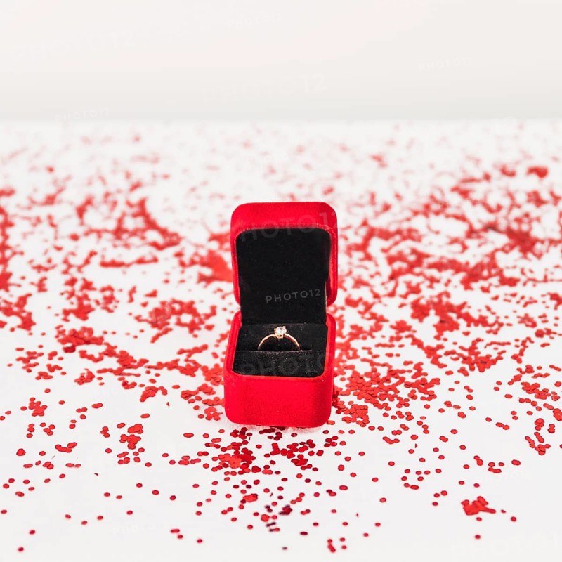 Jewellery box with ring near confetti