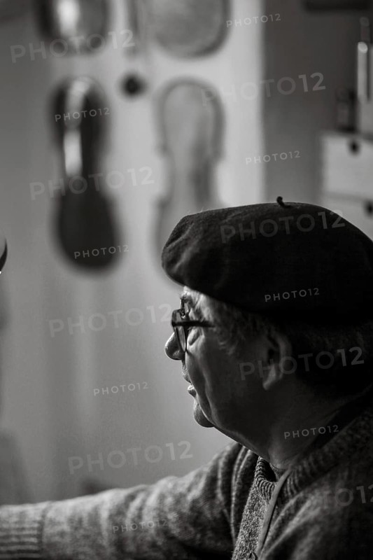 Portrait of senior violinmaker in workshop in Cremona