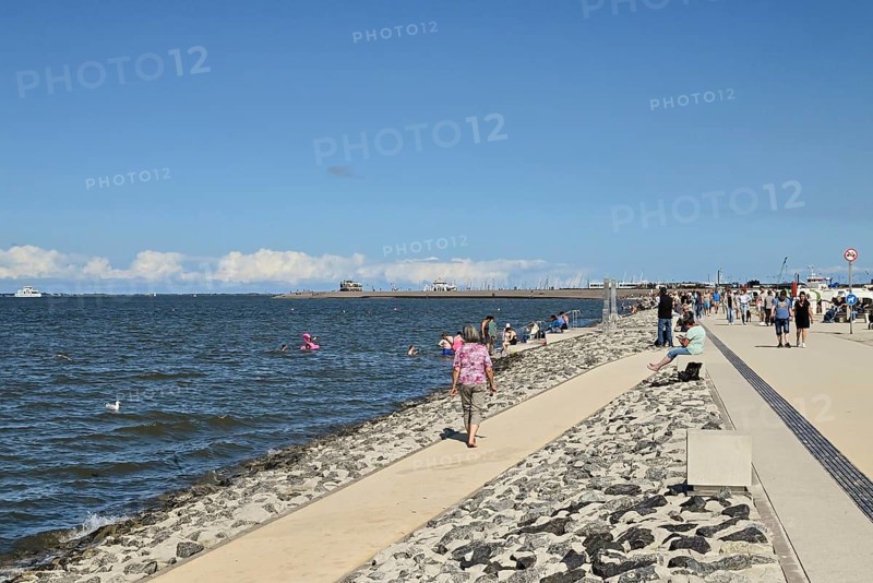 Concreted seashore with bathers