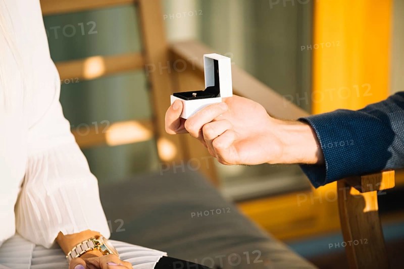 Man s hand showing engagement ring box her girlfriend