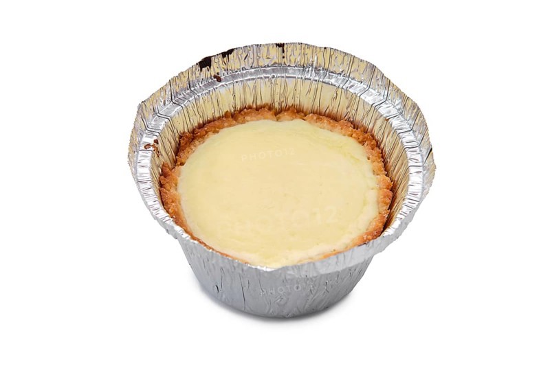 High angle view of vanilla cake in a baking foil dish isolated on white background