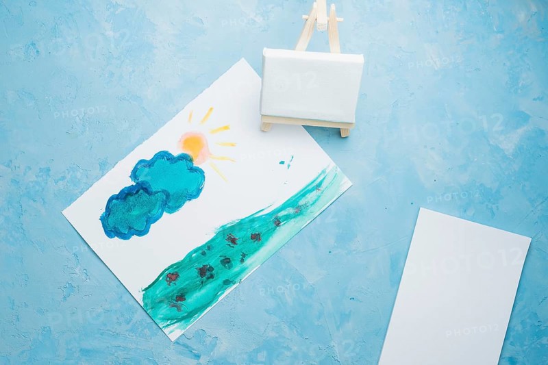 Hand drawn paper painting with mini easel watercolor backdrop