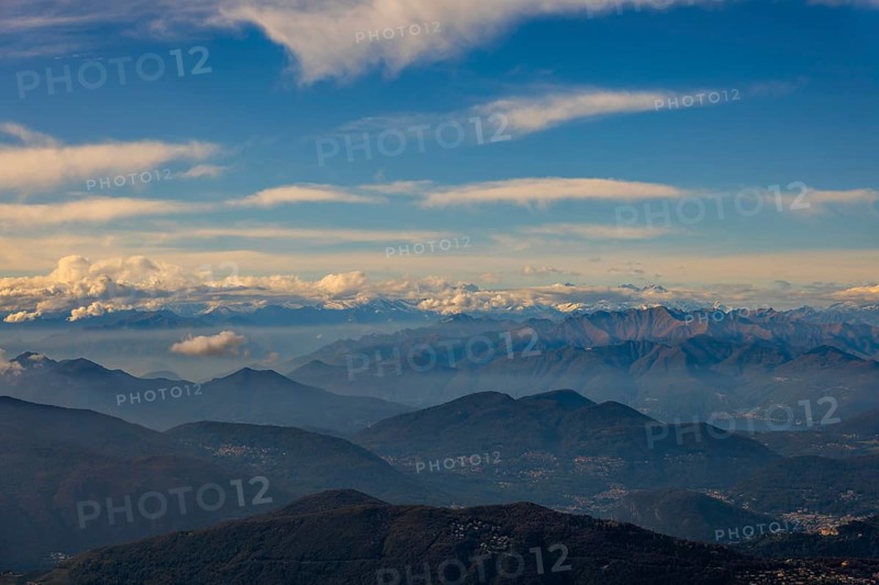 Aerial View over a Beautiful Mountainscape and And Snow Capped Mountain and with Floating Clouds in a Sunny Day in Ticino