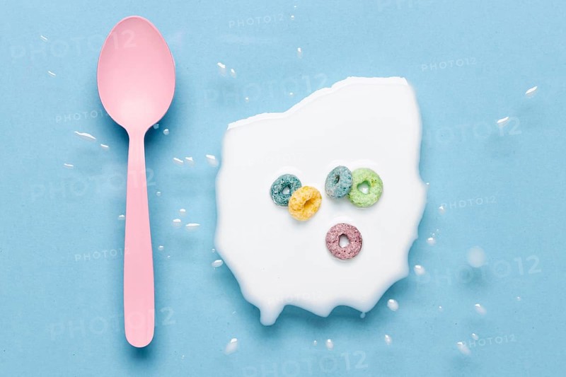 Flat lay pink spoon splash milk with cereals